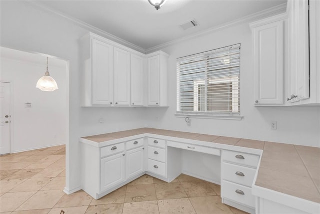 unfurnished office featuring light tile patterned floors, built in desk, and ornamental molding