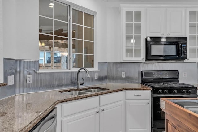 kitchen with sink, white cabinetry, tasteful backsplash, dark stone counters, and black appliances