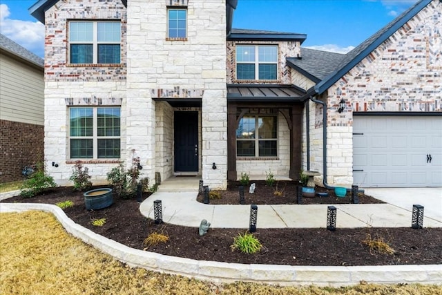 312 Olinda Way, Liberty Hill, TX 78642 - view of exterior entry with a standing seam roof, stone siding, concrete driveway, an attached garage, and metal roof