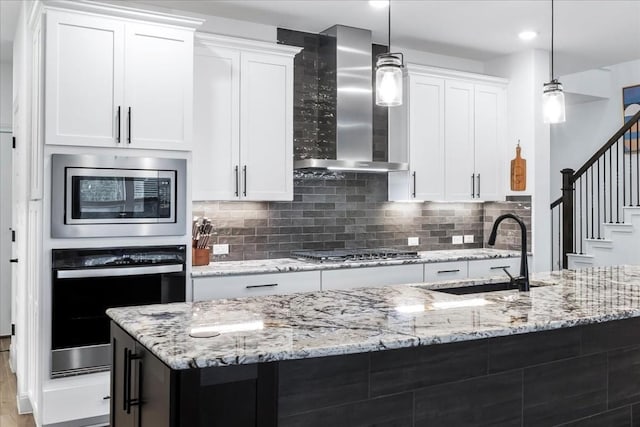 312 Olinda Way, Liberty Hill, TX 78642 - kitchen with black cooktop, oven, stainless steel microwave, wall chimney exhaust hood, and a sink