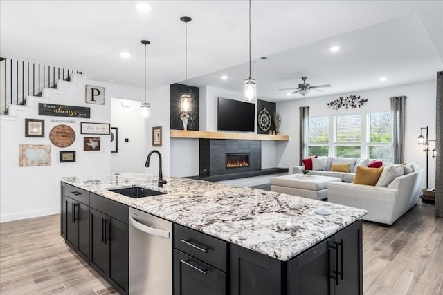 312 Olinda Way, Liberty Hill, TX 78642 - kitchen featuring a sink, dishwasher, light wood-type flooring, dark cabinets, and recessed lighting