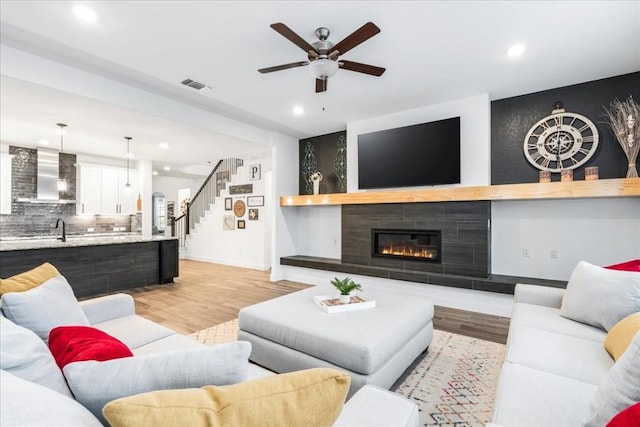 312 Olinda Way, Liberty Hill, TX 78642 - living area featuring a tile fireplace, a ceiling fan, light wood-style flooring, baseboards, and visible vents