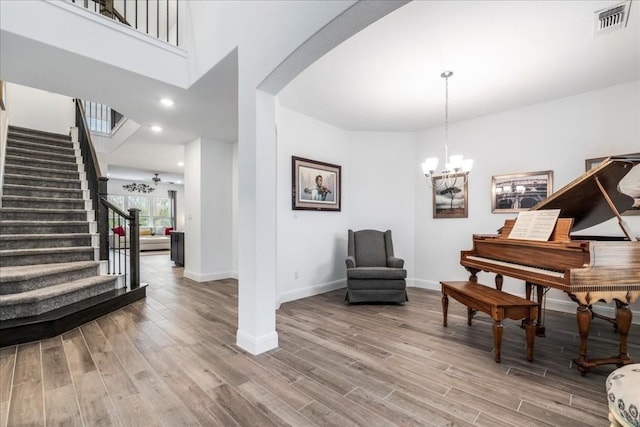 312 Olinda Way, Liberty Hill, TX 78642 - living area with stairs, an inviting chandelier, arched walkways, visible vents, and wood finished floors