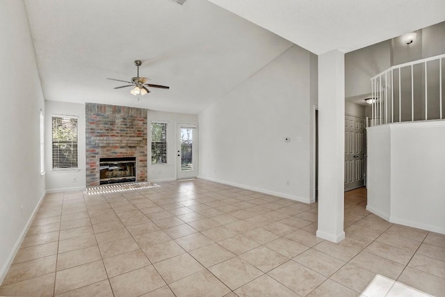 unfurnished living room featuring a healthy amount of sunlight, light tile patterned floors, a fireplace, and ceiling fan