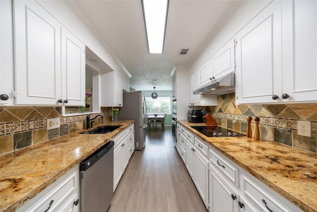 kitchen with white cabinetry, light stone countertops, and stainless steel appliances