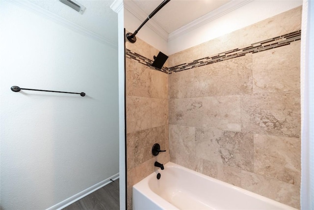 bathroom with crown molding, wood-type flooring, and tiled shower / bath combo