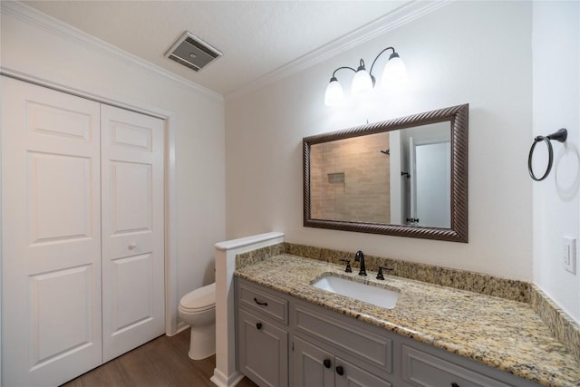 bathroom with hardwood / wood-style flooring, vanity, ornamental molding, toilet, and walk in shower