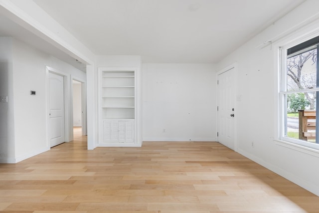 unfurnished room with built in features and light wood-type flooring