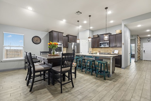 dining area with lofted ceiling and light hardwood / wood-style floors