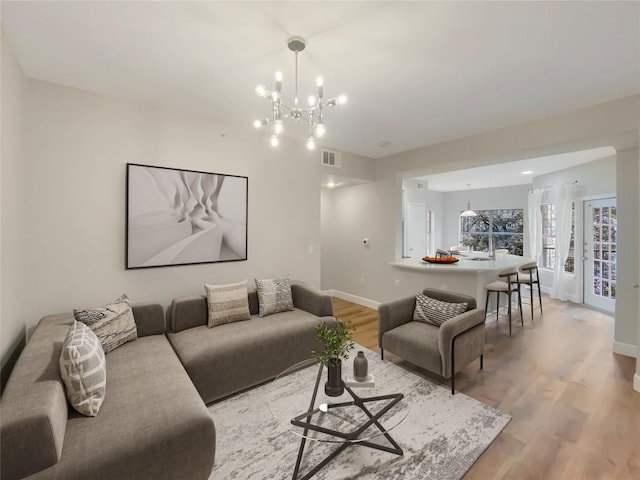 living room featuring a notable chandelier and light hardwood / wood-style floors