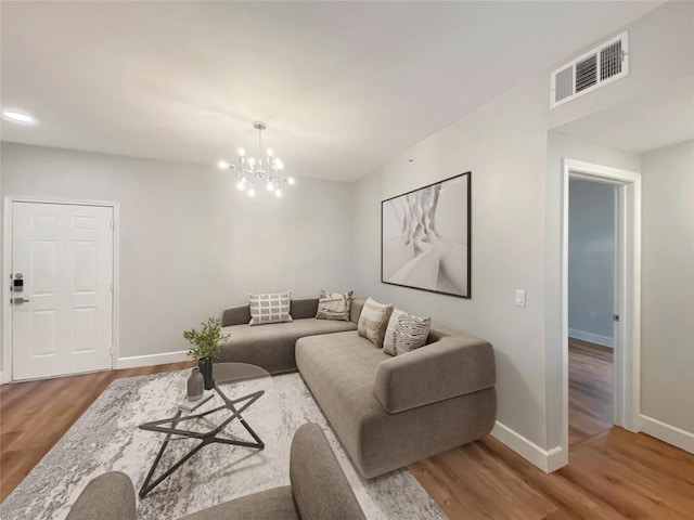 living room with an inviting chandelier and hardwood / wood-style floors