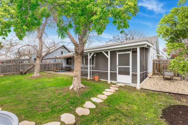 back of property with a lawn, a sunroom, and a patio