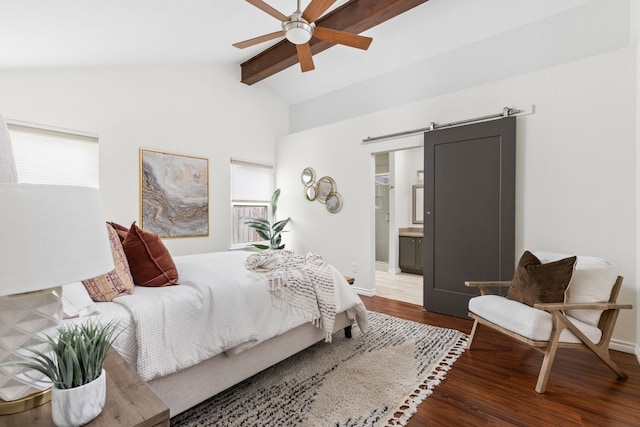 bedroom with dark wood-type flooring, ceiling fan, vaulted ceiling with beams, ensuite bathroom, and a barn door