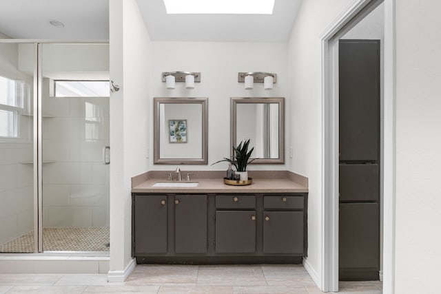 bathroom featuring vanity, a skylight, and walk in shower