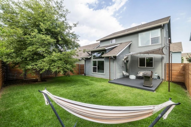 back of property with a lawn, a fenced backyard, and a patio area