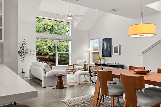 dining space with visible vents, a healthy amount of sunlight, high vaulted ceiling, and concrete floors