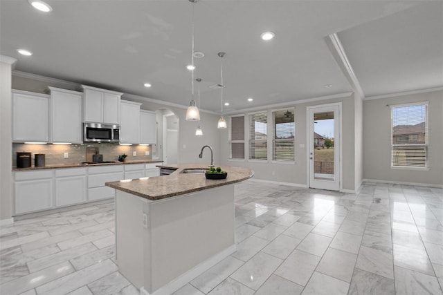 kitchen featuring an island with sink, sink, white cabinets, hanging light fixtures, and black gas stovetop