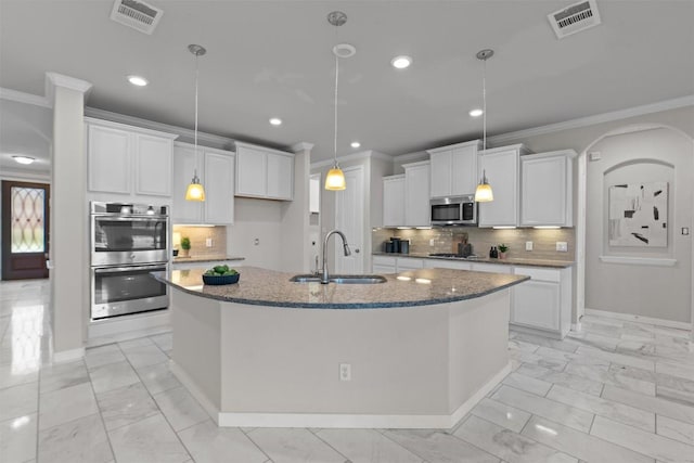 kitchen featuring stainless steel appliances, a kitchen island with sink, sink, and white cabinets