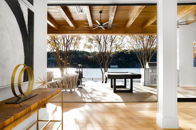 doorway featuring a water view, wood ceiling, light hardwood / wood-style flooring, and beamed ceiling