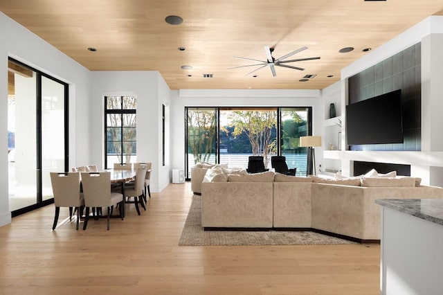 living room with plenty of natural light, light hardwood / wood-style floors, and wooden ceiling