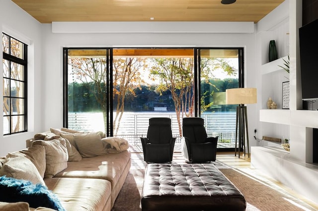 living room featuring a water view and wooden ceiling