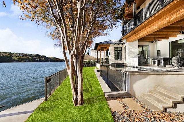 exterior space featuring a water view, a yard, and a bar