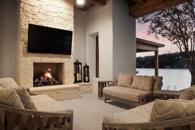 living room with a water view and a stone fireplace