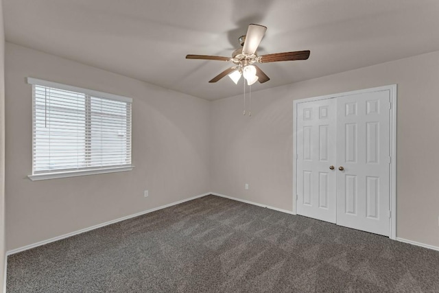 unfurnished bedroom with a ceiling fan, baseboards, dark colored carpet, and a closet