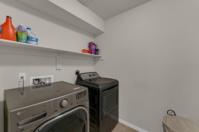 clothes washing area featuring laundry area, independent washer and dryer, and baseboards