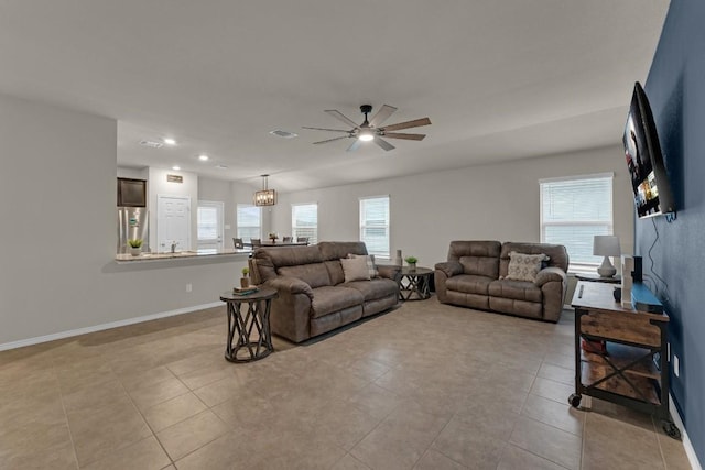 living area with a healthy amount of sunlight, visible vents, baseboards, and light tile patterned floors