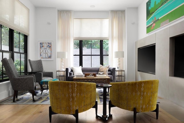 living area with a towering ceiling and light hardwood / wood-style floors