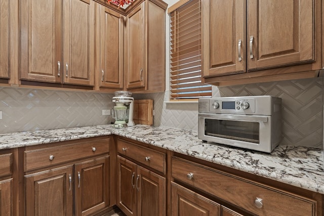 kitchen with tasteful backsplash and light stone countertops