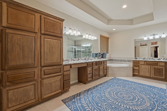 bathroom featuring a raised ceiling, vanity, separate shower and tub, and tile patterned floors