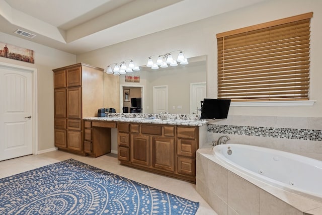 bathroom featuring tile patterned flooring, vanity, tiled tub, and a tray ceiling