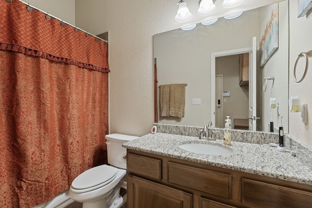 bathroom featuring a shower with curtain, vanity, and toilet