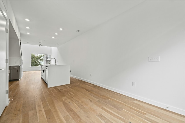 unfurnished living room featuring sink and light wood-type flooring