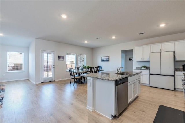 2501 Bear Juice Vw, Leander, TX 78641 - kitchen with freestanding refrigerator, stainless steel dishwasher, a sink, light stone countertops, and light wood finished floors