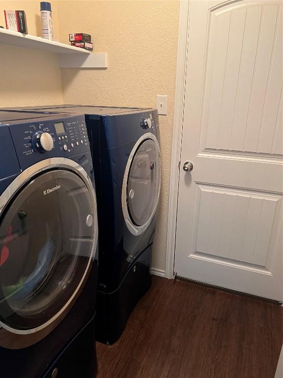 laundry room with dark hardwood / wood-style flooring and washer and clothes dryer