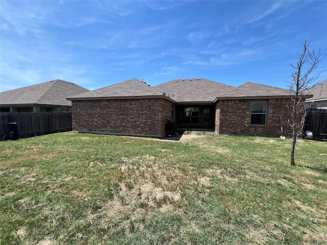 rear view of property with a lawn