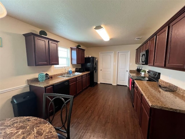 kitchen with dark wood-type flooring, sink, a textured ceiling, dark brown cabinets, and black appliances