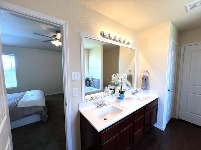 bathroom with vanity, ceiling fan, and a tub to relax in