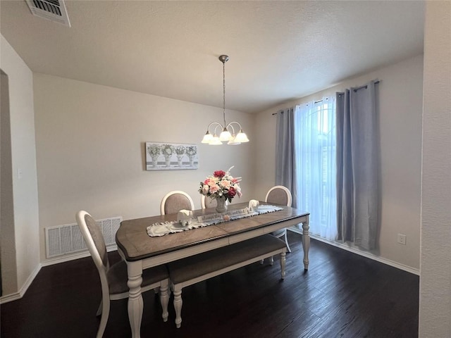 dining space featuring baseboards, dark wood finished floors, a chandelier, and visible vents