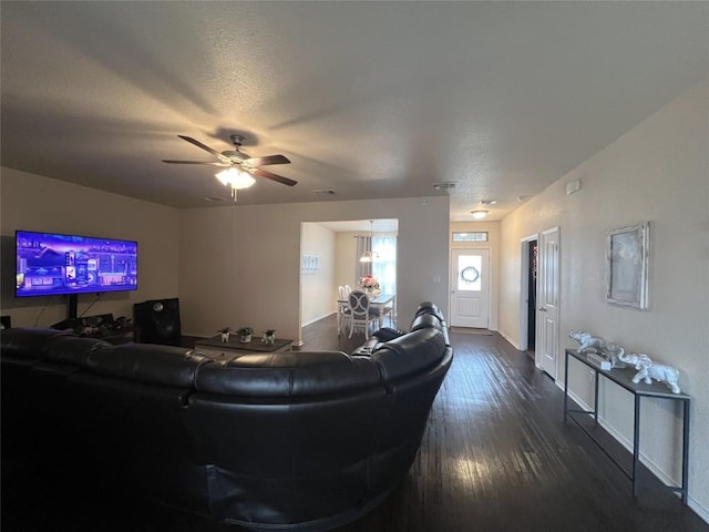 living room featuring dark wood-type flooring and ceiling fan