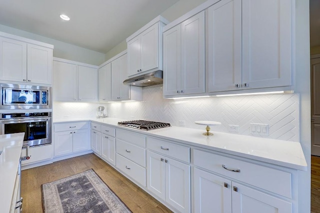 kitchen with white cabinetry, tasteful backsplash, stainless steel appliances, and light wood-type flooring