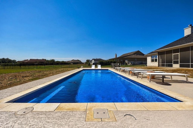 view of pool featuring a patio and a sunroom