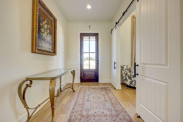 foyer featuring a barn door and light hardwood / wood-style floors