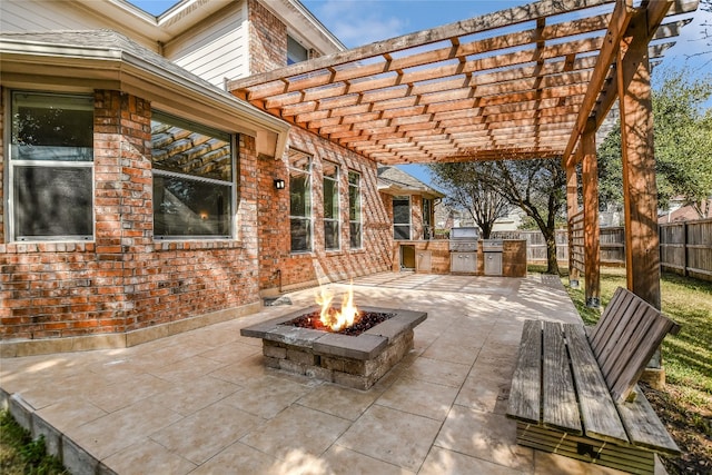 view of patio / terrace featuring an outdoor kitchen, a pergola, and an outdoor fire pit