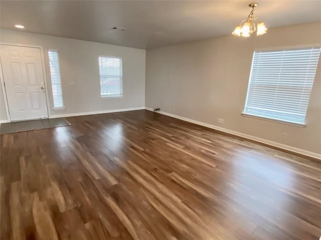 interior space featuring dark wood-type flooring and an inviting chandelier