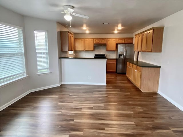 kitchen featuring dark hardwood / wood-style flooring, stainless steel fridge, ceiling fan, and range