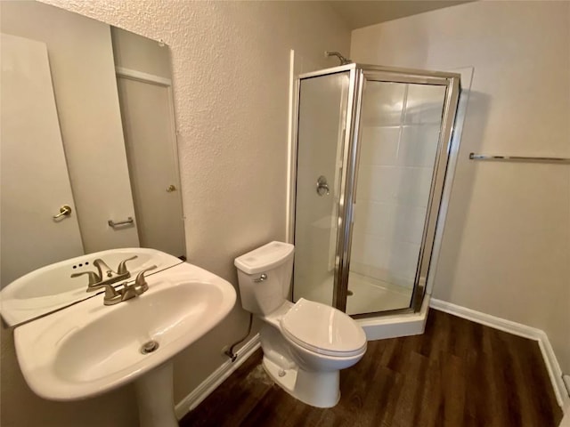 bathroom with a shower with door, wood-type flooring, sink, and toilet